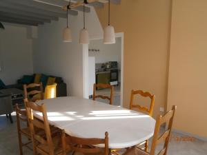 a dining room with a white table and chairs at Gîte Chez Louve Bleue 3 étoiles-Label Tourisme et Hand in Le Grand-Abergement