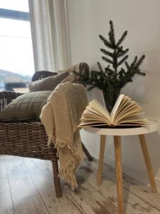 un livre ouvert sur une table à côté d'un arbre de Noël dans l'établissement Cztery Pokoje Wetlina, à Wetlina