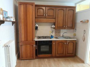 uma cozinha com armários de madeira e um forno com placa de fogão em Appartamento Cascate delle Marmore em Le Marmore