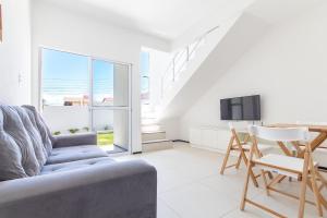 MangabeiraにあるBeach Townhouses #C8 - Exclusivo por Carpediemのソファとテーブルとテレビのあるリビングルーム