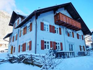 ein Gebäude mit Balkon darüber im Schnee in der Unterkunft Haus Barbara in Wald am Arlberg