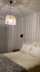 ヴィラ・ノヴァ・デ・ミルフォンテスにあるNa Casa da Fátimaのベッドルーム1室(ベッド1台、シャンデリア付)