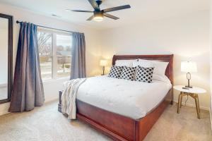 a bedroom with a bed with a ceiling fan and a window at OZK Trail House in Bentonville