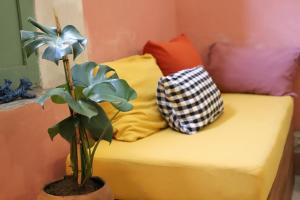 a bed with two pillows and a plant on it at Nuik Casa Tropical in Mérida