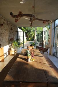 Nuik Casa Tropical في ميريدا: طاولة خشبية كبيرة في غرفة بها نباتات
