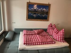 un sofá con almohadas rojas y blancas. en Apartment Heimatliebe, en Scheffau am Wilden Kaiser
