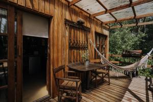 een veranda met een hangmat en een tafel en stoelen bij Cabañas en el Bosque a 5 minutos del mar - Estancia CH in Punta del Este