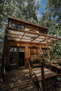 a cabin in the woods with a wooden deck at Cabañas en el Bosque a 5 minutos del mar - Estancia CH in Punta del Este