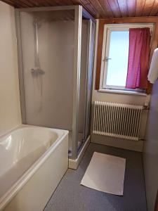 a bathroom with a bath tub and a window at Haus Barbara in Wald am Arlberg