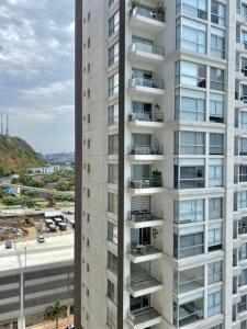 un edificio de apartamentos alto y blanco con balcones. en #3 Luxury Suite en Puerto Santa Ana, en Guayaquil