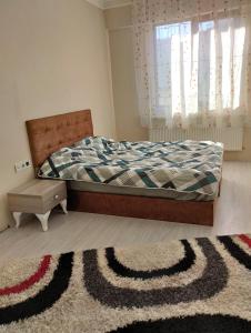 a bedroom with a bed and a rug and a window at Sefam konaklama in Erzurum