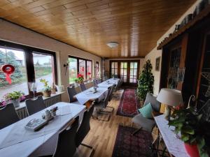 a restaurant with long tables and chairs and windows at Hotel Schönblick in Bad Herrenalb