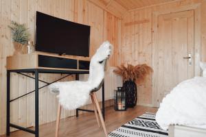 a white ostrich chair in a room with a tv at Cuib din Fagaras in Avrig