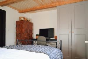 a bedroom with a bed and a desk and a tv at Cuib din Fagaras in Avrig