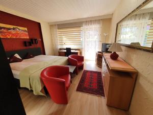 - une chambre avec un lit, un bureau et des chaises dans l'établissement Hotel Schönblick, à Bad Herrenalb