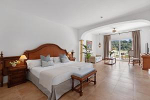 ein Schlafzimmer mit einem großen Bett und ein Wohnzimmer in der Unterkunft La Moraleja The Quiet Hotel - Adults Only in Cala de Sant Vicent