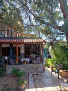 a house with a porch and a patio at Handmade peaceful cozy house near the beach in Nea Kalikratia