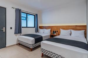 Cette chambre comprend 2 lits et une fenêtre. dans l'établissement Hotel Mody Merida, à Mérida