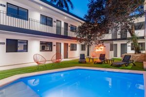 - une piscine en face d'un bâtiment avec des chaises et une maison dans l'établissement Hotel Mody Merida, à Mérida
