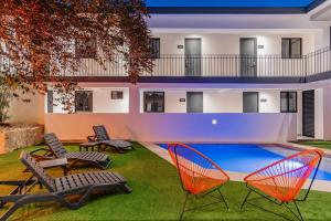 a house with a swimming pool with two lawn chairs at Hotel Mody Merida in Mérida