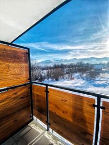 a balcony with a view of the snow covered mountains at Villa 84 & Apartments Jacuzzi & Sauna in Zakopane
