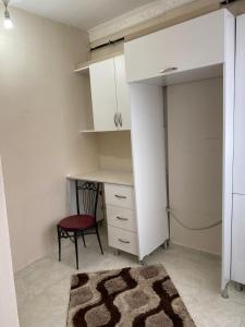 Cette chambre comprend un bureau, une chaise et un placard. dans l'établissement Sefam konaklama, à Erzurum