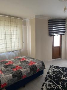 um quarto com uma cama e uma janela em Sefam konaklama em Erzurum