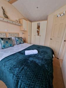 a bedroom with a large bed with a towel on it at Caravan in the Cotswolds in Cirencester