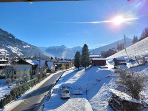 a snow covered street in a town with mountains in the background at Ferienhaus Gastein in Bad Hofgastein