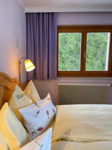 a bedroom with two beds and a window at Heutaler Hof - Hotel im Naturidyll in Unken