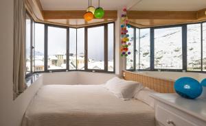 シエラネバダにあるApartamentos en la Plaza de Sierra Nevada Impala 2C Parking incluidoの窓と浴槽のある部屋のベッド