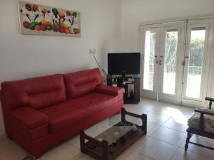 a living room with a red couch and a tv at Soho Departamento Temporario in Santa Fe