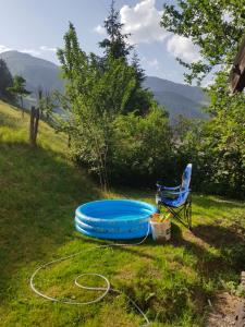 une baignoire bleue dans l'herbe à côté d'une chaise dans l'établissement Ferienhaus Gastein, à Bad Hofgastein