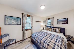 ein Schlafzimmer mit einem Bett und zwei Fenstern in der Unterkunft Vermont Meadow House in West Rutland