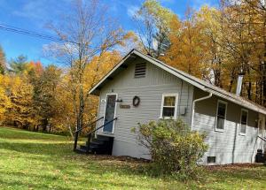 ein kleines weißes Haus mitten auf einem Feld in der Unterkunft Vermont Meadow House in West Rutland