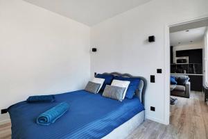 ein Schlafzimmer mit einem großen Bett mit blauer Bettwäsche in der Unterkunft Appartement aux Portes de Paris in Saint-Denis