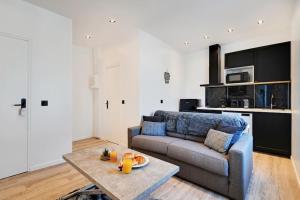 a living room with a couch and a table at Appartement aux Portes de Paris in Saint-Denis