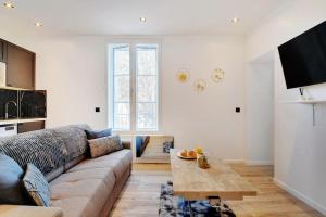 uma sala de estar com um sofá e uma mesa em Appartement aux Portes de Paris em Saint-Denis