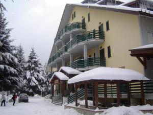 duży budynek z śniegiem na ziemi w obiekcie Hotel La Fattoria w mieście Camigliatello Silano