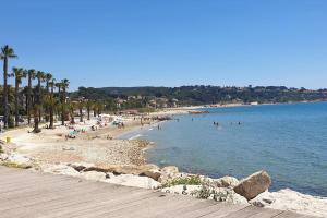 Plaża z grupą ludzi w wodzie w obiekcie Studio Centre village w mieście Bandol