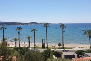 plaża z palmami i łodziami w wodzie w obiekcie Studio Centre village w mieście Bandol
