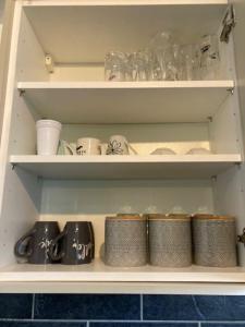 a shelf with cups and other items in a kitchen at Make it your home and relax in Fallings Park