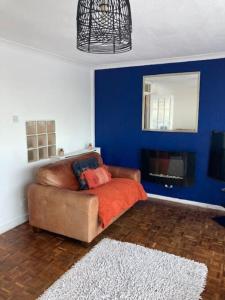 a living room with a couch and a blue wall at Make it your home and relax in Fallings Park