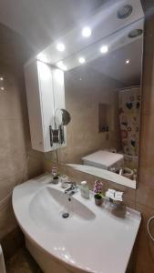 uma casa de banho com um lavatório branco e um espelho. em Nice Holiday House em Piraeus