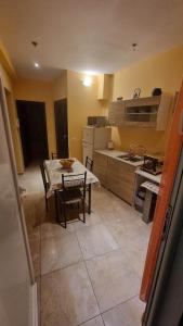 a kitchen with a table and a kitchen with a table and chairs at Nice Holiday House in Piraeus