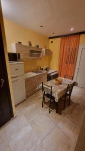 uma cozinha com uma mesa e cadeiras numa cozinha em Nice Holiday House em Piraeus
