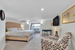 a bedroom with a bed and a couch and a chair at Lakeshore Vermont in Colchester