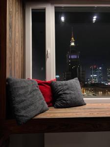 a window with a view of a city at night at The View studio in Warsaw