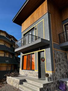 a house with a front door and stairs to it at 3 Cottage Near The Forest in Bakuriani