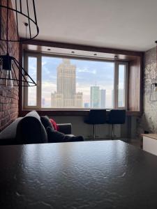 - un salon avec une table et une grande fenêtre dans l'établissement The View studio, à Varsovie